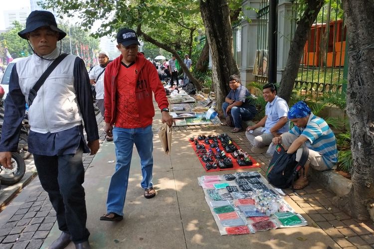Beberapa pedagang menjajakan dagangannya di trotoar Medan Merdeka Selatan yang terletak dekat dengan Patung Kuda yang merupakan titik masuk massa ke area aksi MK (27/6)