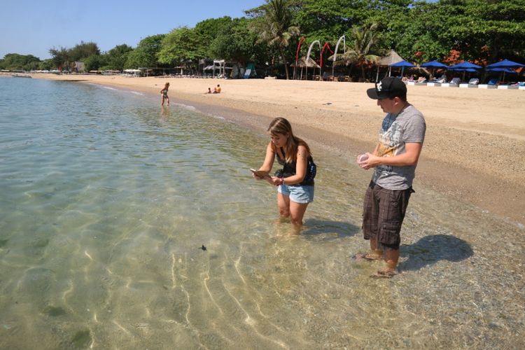 Dua wisatawan mancanegara asal Jerman akan melepaskan penyu dari tempat konservasinya di Pantai Segara Ayu, Sanur, Bali, Jumat (28/9/2018).
