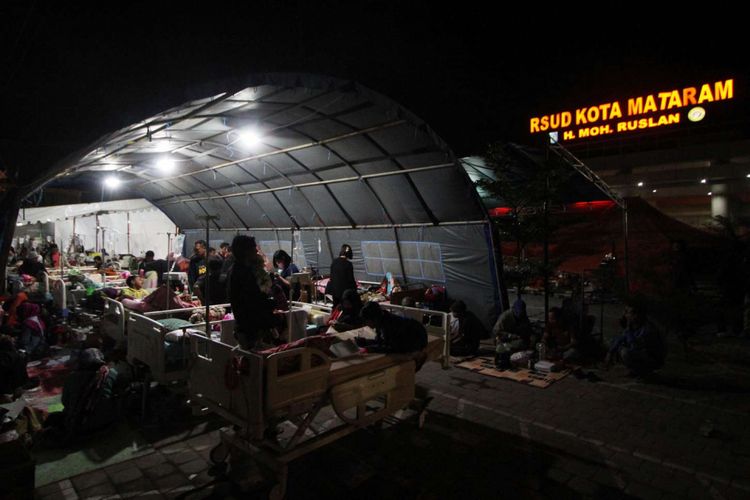 Pasien menjalani perawatan di tenda pengungsian yang berada di depan Rumah Sakit Umum Daerah Kota Mataram, Nusa Tenggara Barat, Senin (6/8/2018). Sebanyak 151 pasien rawat inap dan korban gempa menjalani perawatan di tenda dikarenakan kondisi RSUD Kota Mataram yang rusak akibat gempa.