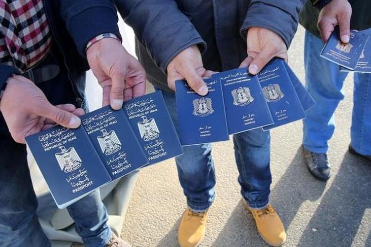 Para migran asal Irak dan Suriah menunjukkan paspor yang mereka gunakan untuk mendapat tiket kapal feri memasuki Eropa.