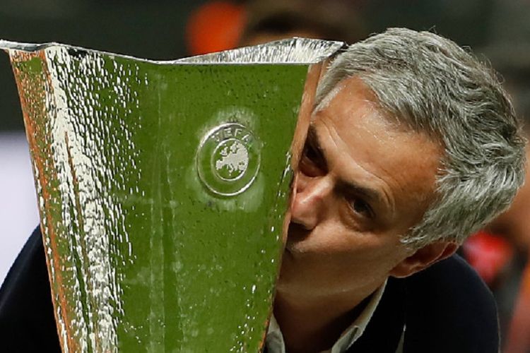 Jose Mourinho mencium trofi Liga Europa seusai mengantarkan Manchester United menjadi kampiun dengan mengalahkan Ajax Amsterdam di Stockholm, Rabu (24/5/2017). 