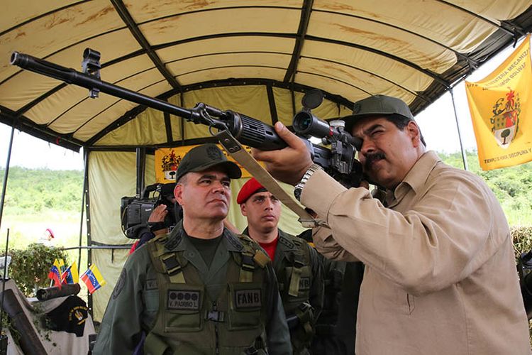 Presiden Venezuela Nicolas Maduro mencoba senapan buatan Rusia saat latihan militer bersama kedua negara di Carcas, Januari 2017 lalu.