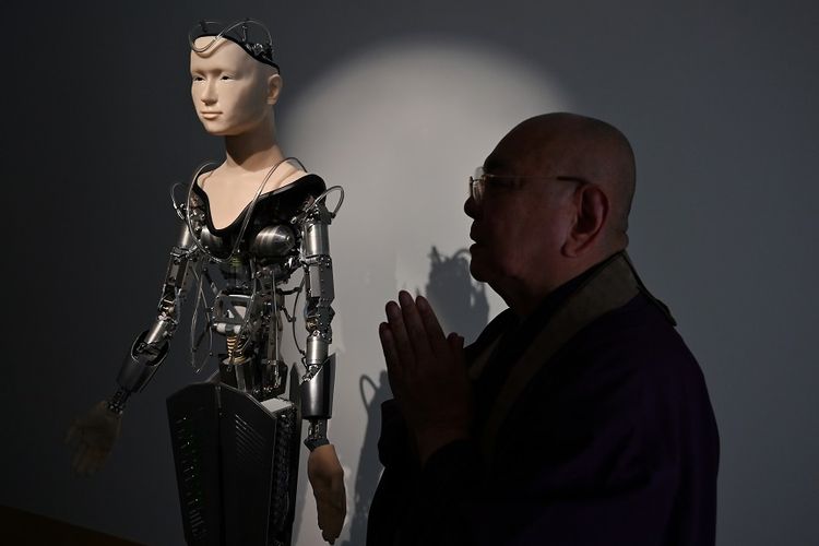 Biksu Tensho Goto, bersama robot biksu yang ada di Kuil Kodaiji, Kyoto, Jepang, yang akan membacakan doa untuk pengunjung kuil.