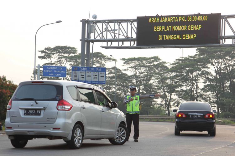 Petugas kepolisian mengarahkan kendaraan yang melintas saat uji coba sistem ganjil genap di Pintu Tol Kunciran 2, Tangerang, Banten, Senin (16/4/2018). Kepala Badan Pengelola Transportasi Jabodetabek (BPTJ) Bambang Prihartono menargetkan, kebijakan sistem ganjil-genap di tol Tangerang-Jakarta bisa mengurangi kepadatan menuju Jakarta hingga 50 persen.