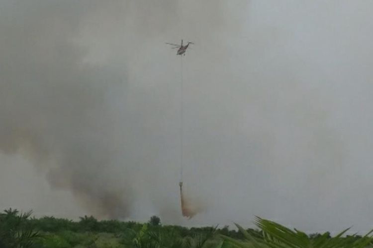 Heli Sikorsky S61 melakukan water bombing di lahan yang terbakar di Desa Teluk Bano II, Kecamatan Pekaitan, Rohil, Riau, Rabu (3/7/2019).