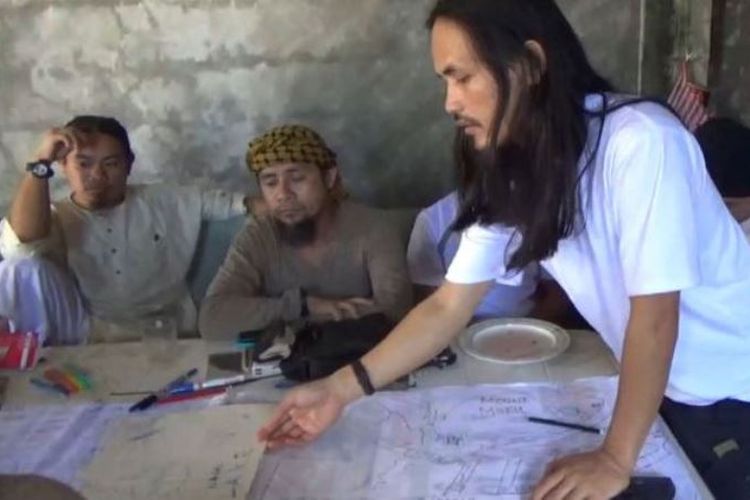 Abdullah Maute (berdiri) menunjuk peta dalam pertemuan dengan Isnilon Hapilon (kedua dari kiri), yang merupakan pemimpin kelompok Abu Sayyaf. Foto ini didapat militer Filipina. 