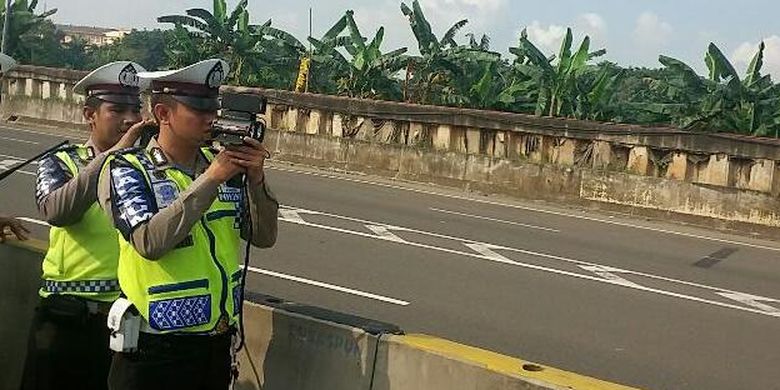 Petugas kepolisian dari Direktorat Lalu Lintas Polda Metro Jaya melakukan uji coba pembatasan kecepatan dengan menggunakan Speed Gun di tol yang mengarah ke bandara pada KM 25-900, Jakarta, Sabtu (12/3/2016).