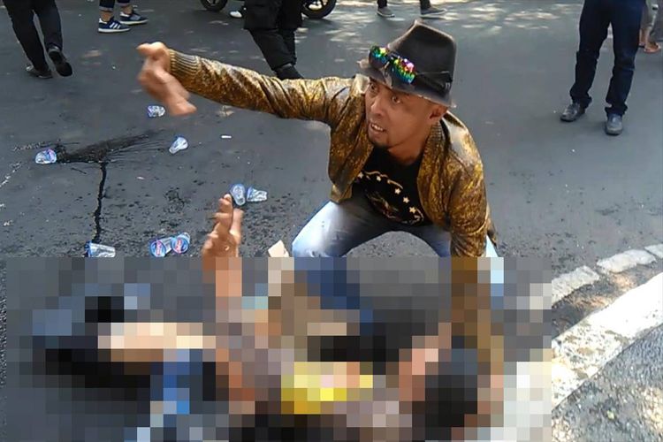 Seseorang coba memberikan pertolongan kepada seorang anggota polisi yang terbakar saat terjadi insiden kericuhan dalam aksi unjukrasa di ruas Jalan Siliwangi depan gerbang Pendopo Bupati Cianjur, Jawa Barat, Kamis (15/08/2019) siang