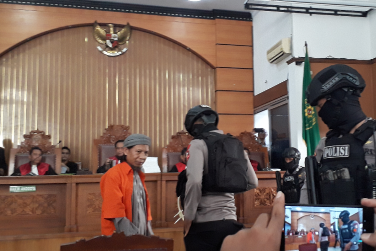 Terdakwa kasus terorisme Aman Abdurrahman tiba di ruang sidang utama Pengadilan Negeri Jakarta Selatan untuk menjalani sidang pembacaan tuntutan, Jumat (18/5/2018). Aman tampak dikawal polisi bersenjata laras panjang.