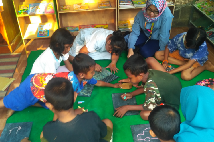 Anak-anak di Kampoeng Batja Kapur di Jember, Jawa Timur, belajar menggambar menggunakan media kapur.