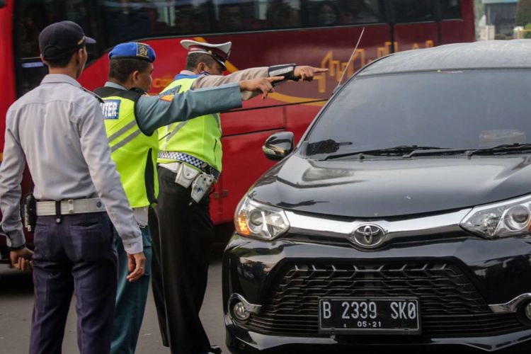 Sejumlah petugas gabungan memberi arahan kepada pengendara mobil pada uji coba ganjil genap di ruas Tol Jagorawi, Jakarta, Senin (16/4/2018). Uji coba yang dilakukan setiap hari Senin-Jumat kecuali hari libur nasional tersebut dimulai pukul 06.00 hingga 09.00 WIB diharapkan dapat mengurai kemacetan.