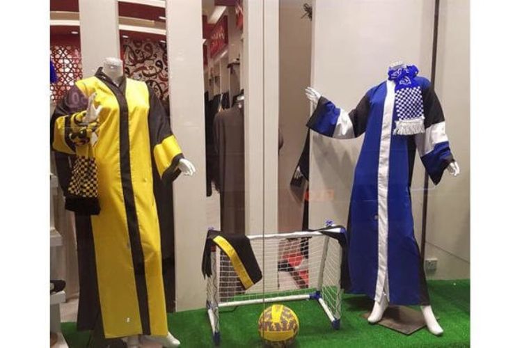 Foto di sebuah toko Arab Saudi yang memajang abaya khusus tim Saudi Pro League. Yakni Al-Ittihad Jeddah (kiri), dan Al-Hilal Riyadh (kanan). Abaya ini dijual setelah otoritas Saudi mengizinkan perempuan masuk ke stadion untuk menonton pertandingan sepak bola