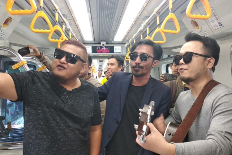 ST12 Zai (Vokalis), Indra (Bassis), dan Pepep (Gitaris/keyboardist) saat mengamen di dalam kereta light rail transit (LRT) Palembang, Sumatera Selatan, Kamis (20/9/2018). Usai ngamen di LRT Palembang, ST 12 berencana untuk membuat video klip.