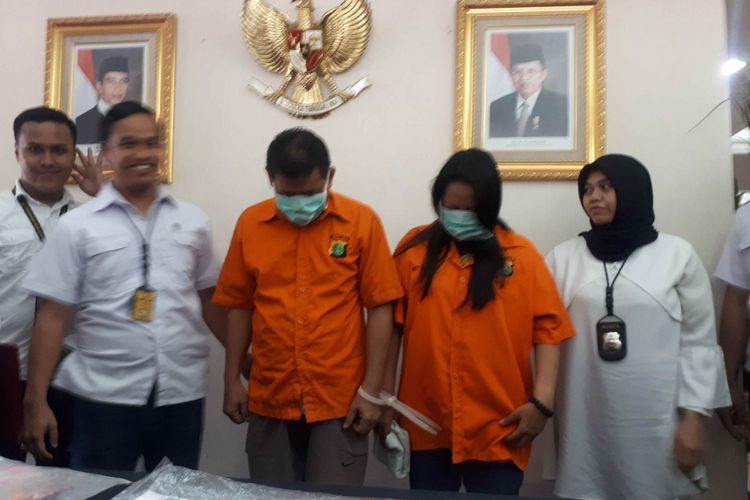 Pasangan suami istri berinisial LW dan GRH yang melakukan aksi penipuan dan penggelapan uang dengan modus menawarkan jasa penukaran mata uang asing di Polda Metro Jaya, Senin (11/2/2019). 