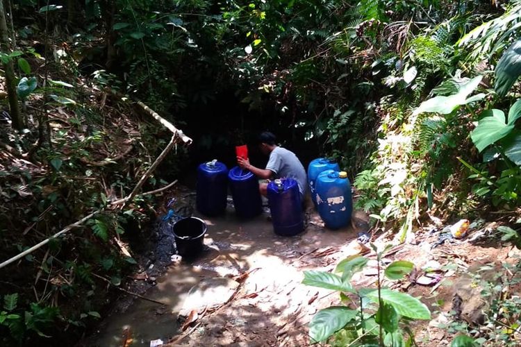 Seorang warga di Kecamatan Cikadu, Kabupaten Cianjur, Jawa Barat sedang mengambil air keruh di kolam penampungan menyusul bencana kekeringan yang sudah terjadi sejak dua bulan terakhir