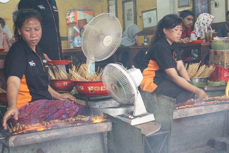 Karyawan Sate Ondomohen Bu Asih sedang membakar puluhan tusuk sate.