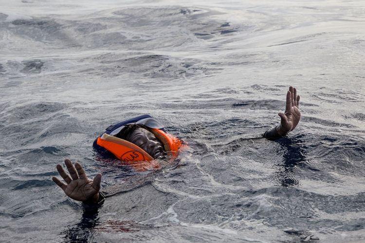 Salah seorang migran Afrika terombang-ambing di laut saat hendak diselamatkan. Foto diambil pada 6 November 2017.