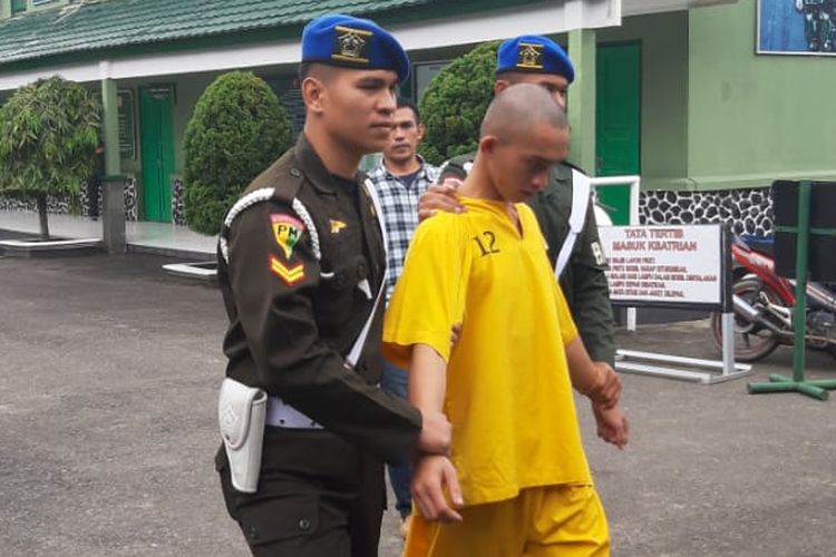 Prada DP dikawal anggota Denpom II Sriwijaya setelah ditangkap petugas. Prajurit baru ini ditangkap atas kasus pembunuhan serta mutilasi terhadap pacarnya sendiri, Jumat (14/6/2019).