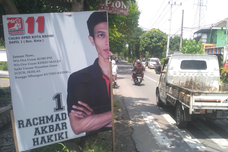 Baliho bergambar Rahmad caleg PSI Kota Kediri, Jawa Timur, yang sengaja dipasang dengan gambar muka separuh.