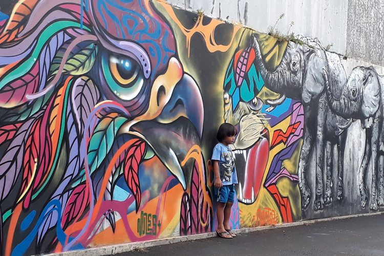 Seorang anak berfoto di dinding bergambar burung yang merupakan bagian dari mural Islami di Gang Abdul Jabar, Jagakarsa, Jakarta Selatan, Rabu (23/5/2018).
