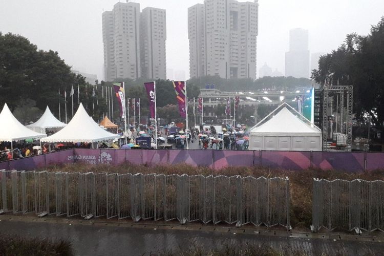 Hujan mengguyur area nonton bareng upacara penutupan Asian Games 2018 di halaman Istora Senayan, Minggu (2/9/2018).
