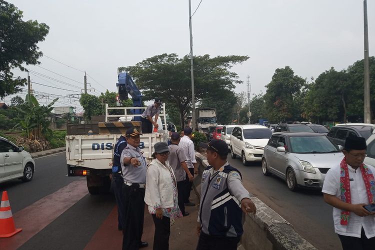 Petugas Suku Dinas Perhubungan Jakarta Timur membuka putaran kendaraan di Jalan I Gusti Ngurah Rai depan Stasiun Buaran lama, Jumat (14/6/2019).