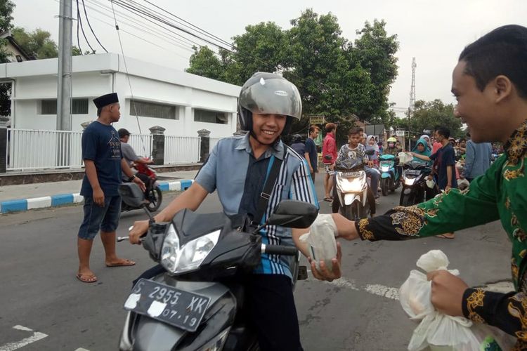 Suasana saat pemuda lintas agama di Mojowarno Kabupaten Jombang Jawa Timur, membagikan paket makanan dan minuman untuk berbuka puasa (takjil), Kamis (30/5/2019) petang.