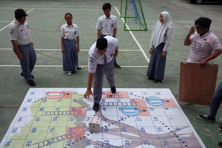 Siswa SMAN 7 Surakarta mengikuti permainan ular tangga dalam sosialisasi KPU Goes To School yang diselenggarakan Komisi Pemilihan umum (KPU) Kota Surakarta bekerja sama dengan Guyub Bocah di sekolah setempat, Selasa (13/11/2018).