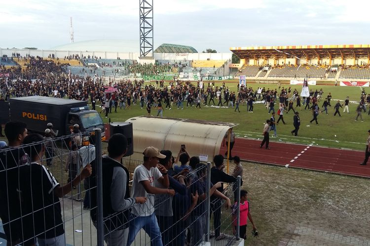 Suporter PSPS Riau masuk kelapangan setelah aksi kerusuhan serta pembakaran saat pertandingan babak kedua vs PSMS Medan di Stadion Kaharudin Nasution, 22 Juni 2019. 