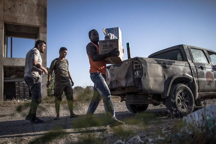 Personel dari pasukan pemerintah yang didukung PBB mendistribusikan makanan dan obat-obatan ke warga yang terjebak konflik di dekat al-Sawani di Tripoli.