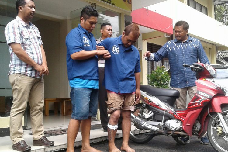 Tersangka Candra Margiyanto (30) dan barang bukti sepeda motor di depan Satreskrim Polresta Surakarta di Solo, Jawa Tengah, Kamis (11/1/2018).