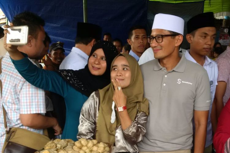 Warga  berebut berswafoto bersama Wakil Gubernur DKI Jakarta Sandiaga Uno ketika berkunjung ke pasar Lemabang Palembang, Sumatera Selatan, Minggu (20/5/2018)
