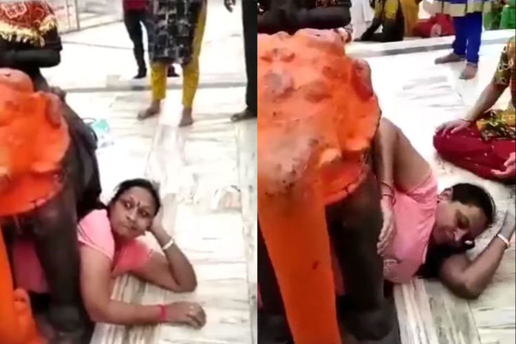 Seorang pengunjung perempuan di kuil Gujarat, India, tak bisa keluar setelah berpose di bawah arca gajah.