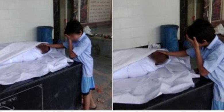 Seorang bocah di India meratapi jasad sang ayah sebelum dikremasi. Ayahnya ternyata merupakan seorang pekerja saluran pembuangan yang tewas karena tali yang menurunkannya ke dalam saluran terputus. (Twitter/Shiv Sunny via BBC)