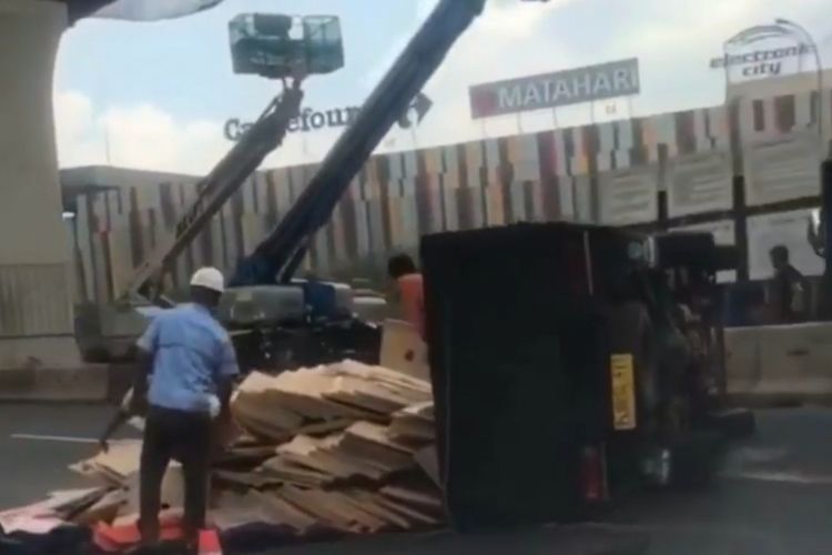 Tampak truk muatan potongan triplek terguling di ruas Jalan Tol Jakarta-Cikampek, KM 13, Bekasi Barat, Kota Bekasi arah Cikampek, Minggu (17/2/2019).