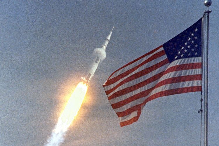 Apollo 11 meluncur di belakang kibaran bendera AS