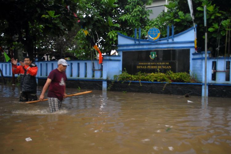 Dua warga melintas banjir di depan Kantor Dinas Perhubungan (Dishub) Kota Sukabumi, Jalan Arif Rahman Hakim, Sukabumi, Jawa Barat, Selasa (11/4/2017).