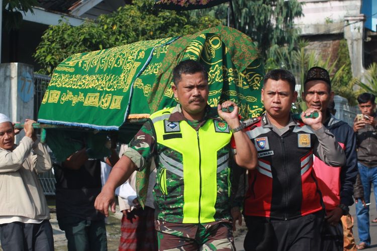 Personil TNI/Polri membantu membawa keranda Ane Liane (22), petugas KPPS 28 Desa Cimacan, Kec. Cipanas, Kab.Cianjur, Jawa Barat yang meninggal karena kelelahan ke tempat peristirahatannya yang terakhir, Jumat (26/04/2019).