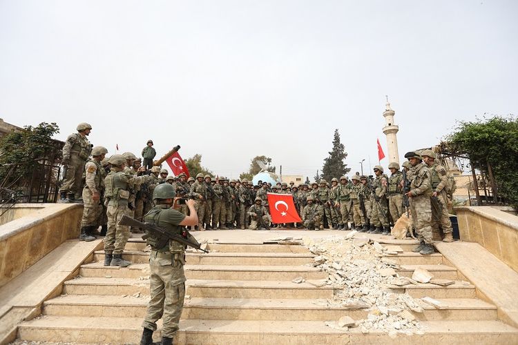 Pasukan Turki berfoto bersama setelah berhasil merebut kota Afrin, Suriah yang selama ini dikuasai milisi Kurdi pada Minggu (18/3.2018).
