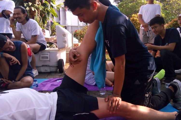 Pelari peserta program Smile Train Indonesia dibantu terapis melakukan peregangan dan pemulihan otot usai melakukan lari 30.000 meter meter di kawasan Taman Kerinci, Kebayoran Baru, Jakarta pada Sabtu (24/8/2019).
 