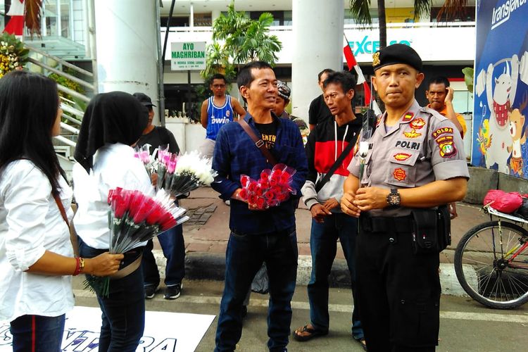 Masyarakat dari Spartan Nusantara bagikan 1.000 tangkai bunga kepada TNI-Polri di Depan Gedung Bawaslu, Jakarta Pusat pada Minggu (26/05/2019).