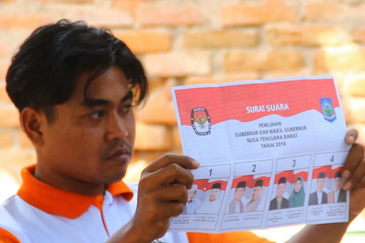 Petugas menunjukkan surat suara dalam perhitungan di Pilkada Provinsi Nusa Tenggara Barat, Rabu (27/6/2018).