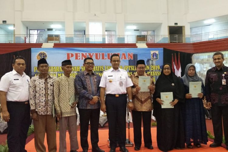 Gubernur DKI Jakarta Anies Baswedan menyerahkan sertifikat tanah kepada warga Jakarta Timur di GOR Ciracas, Kamis (28/2/2019).