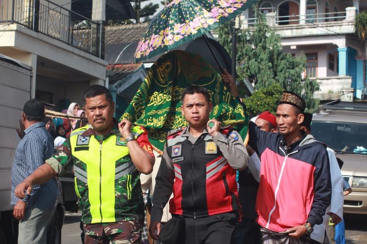 Personil TNI/Polri membantu membawa keranda Ane Liane (22), petugas KPPS 28 Desa Cimacan, Kec. Cipanas, Kab.Cianjur, Jawa Barat yang meninggal karena kelelahan ke tempat peristirahatannya yang terakhir, Jumat (26/04/2019).