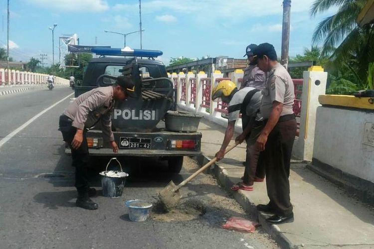 Tim Polsek Lhoksukon, Kabupaten Aceh Utara, menambal badan jalan yang berbulang di lintas nasional Medan-Banda Aceh, di Jembatan Lhoksukon, Kecamatan Lhoksukon, Kabupaten Aceh Utara,Senin (20/5/2019).