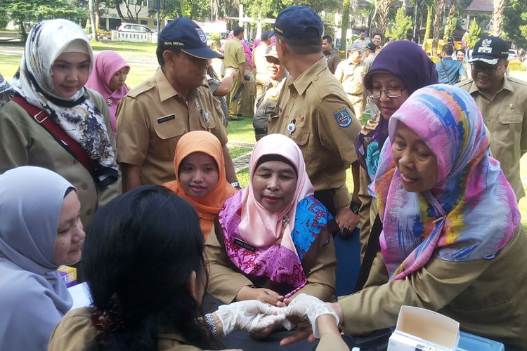 Para pegawai negeri sipil (PNS) di lingkungan Pemerintah Kota Depok mengikuti tes untuk mengecek kadar kolesterol dan gula darah yang diadakan di halaman Balai Kota Depok, Senin (3/7/2017).