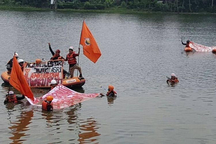 Aktivis lingkungan Ganespa ceburkan diri ke Situ Sasak Tinggi, Pamulang, Tangsel memprotes pembangunan Jalan Tol Cinere-Serpong yang menggusur sempadan situ, Kamis (1/3/2018).