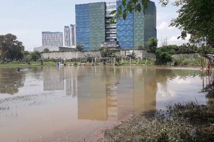 Lapangan bola di Jalan KH Hasyim Kembangan Utara, Jakarta Barat tergenang air dampak luapan hulu Kali Angke pada Kamis (13/12/2018).