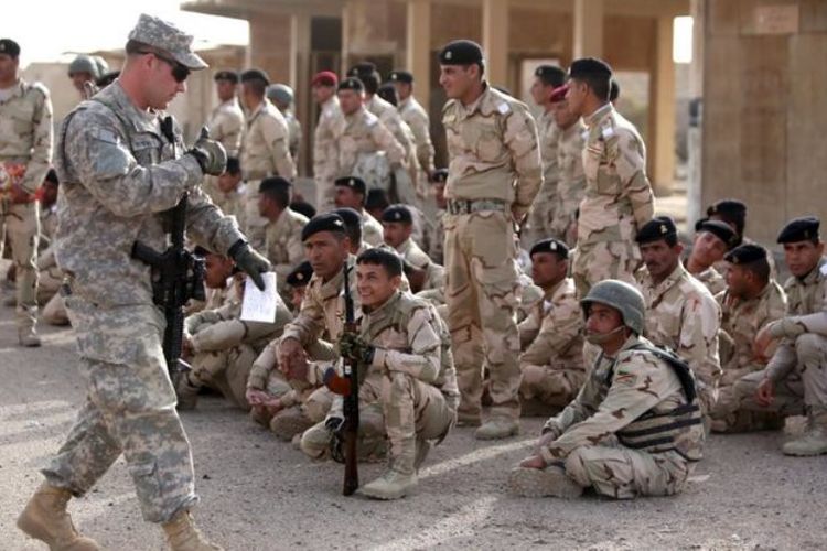 Seorang anggota militer Amerika Serikat memberikan jempol ke arah pasukan Irak di Kompleks Pangkalan Taji, dekat ibu kota Baghdad.