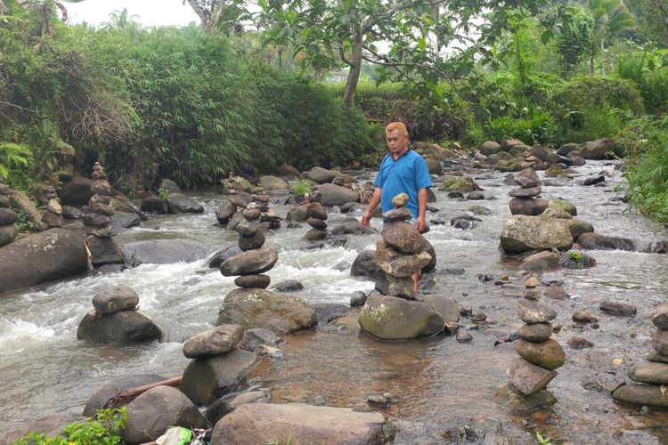 Seorang warga Apet Suherman (49) melihat-lihat puluhan batu bertumpuk di Sungai Cibojong, Desa Jayabakti, Kecamatan Cidahu, Sukabumi, Jawa Barat, Rabu (28/2/2018).